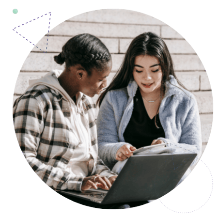 two students studying together with a laptop